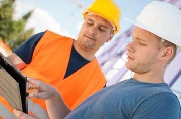 2 construction field workers reviewing screen