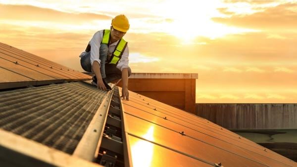 Solar engineer on roof with solar panels